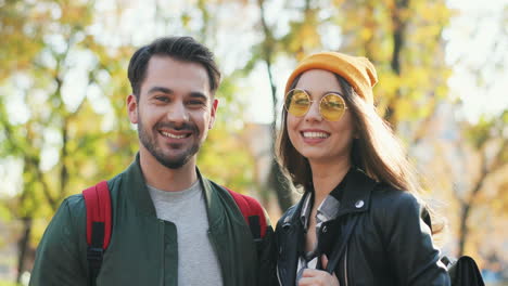 young caucasian woman wearing glasses and beanie and caucasian man looking aside