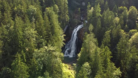 gorgeous aerial view of waterfall in middle of forest, austria, gollinger