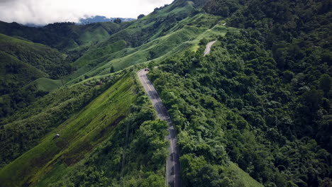 Vista-Aérea-Volando-Sobre-La-Exuberante-Montaña-Verde-De-La-Selva-Tropical-Con-Nubes-De-Lluvia-Durante-La-Temporada-De-Lluvias-En-El-Parque-Nacional-Reservado-De-La-Montaña-Doi-Phuka-En-El-Norte-De-Tailandia