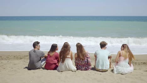 six young people sitting overlooking the ocean