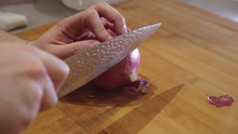 cutting onion with sharp knife on a cut board