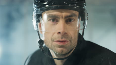 close up of a concentrated male hockey player looking at the camera and breathing in cold air on the ice arena