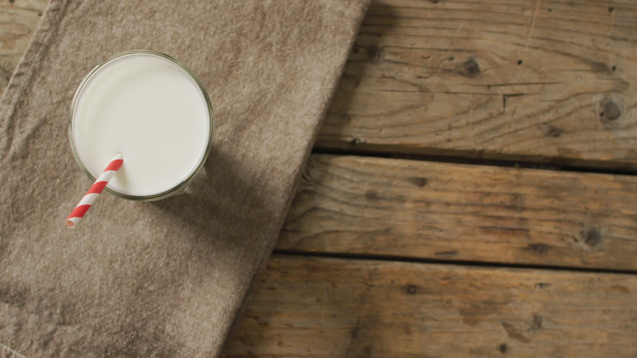 video de un vaso de leche fresca sobre un fondo de madera