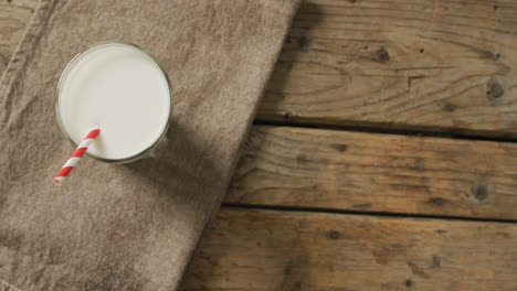 video de un vaso de leche fresca sobre un fondo de madera