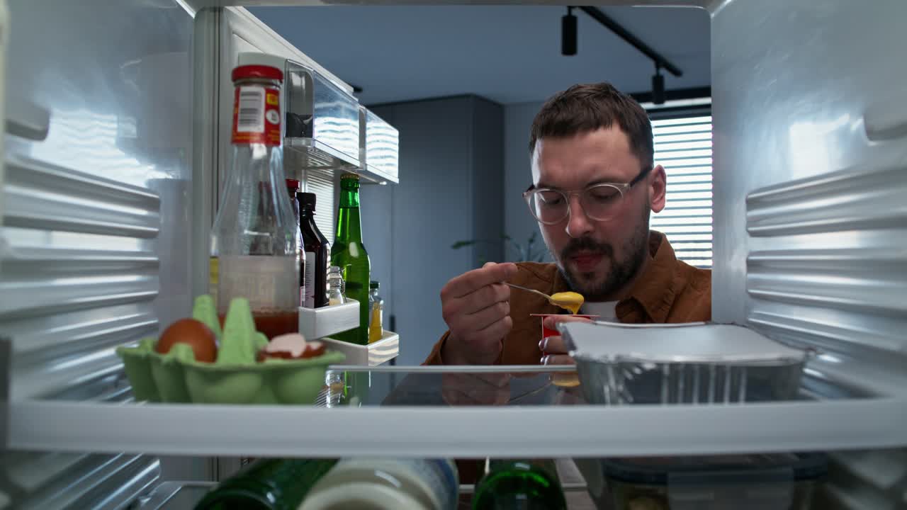 hombre mirando dentro del refrigerador