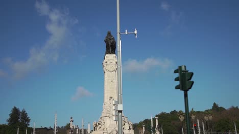 slow motion travelling shot of statue with traffic lights and traffic signs in foreground