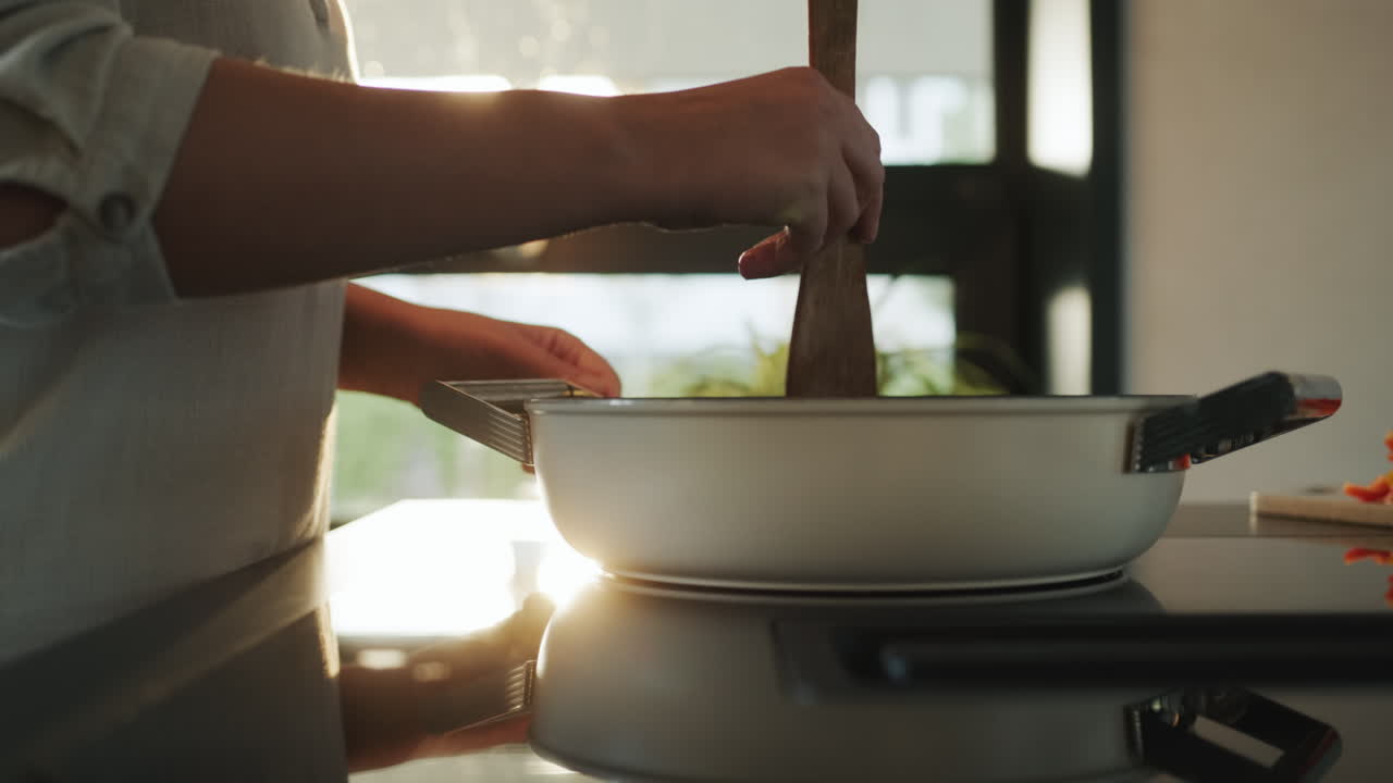 mujer freyendo verduras en una sartén