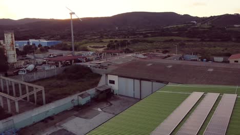 Establisher-aerial-view-of-green-warehouse-with-solar-panels-and-wind-turbine