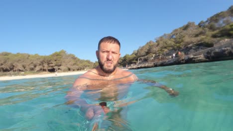 man-swimming-in-a-paradisiacal-beach-with-an-action-camera