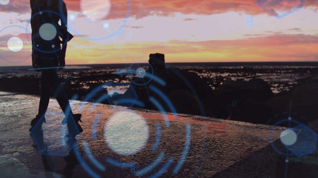 Donna che cammina su un frangiflutti, andando a sinistra, mentre cerchi HUD blu si sovrappongono a una silhouette al tramonto per la tecnologia.