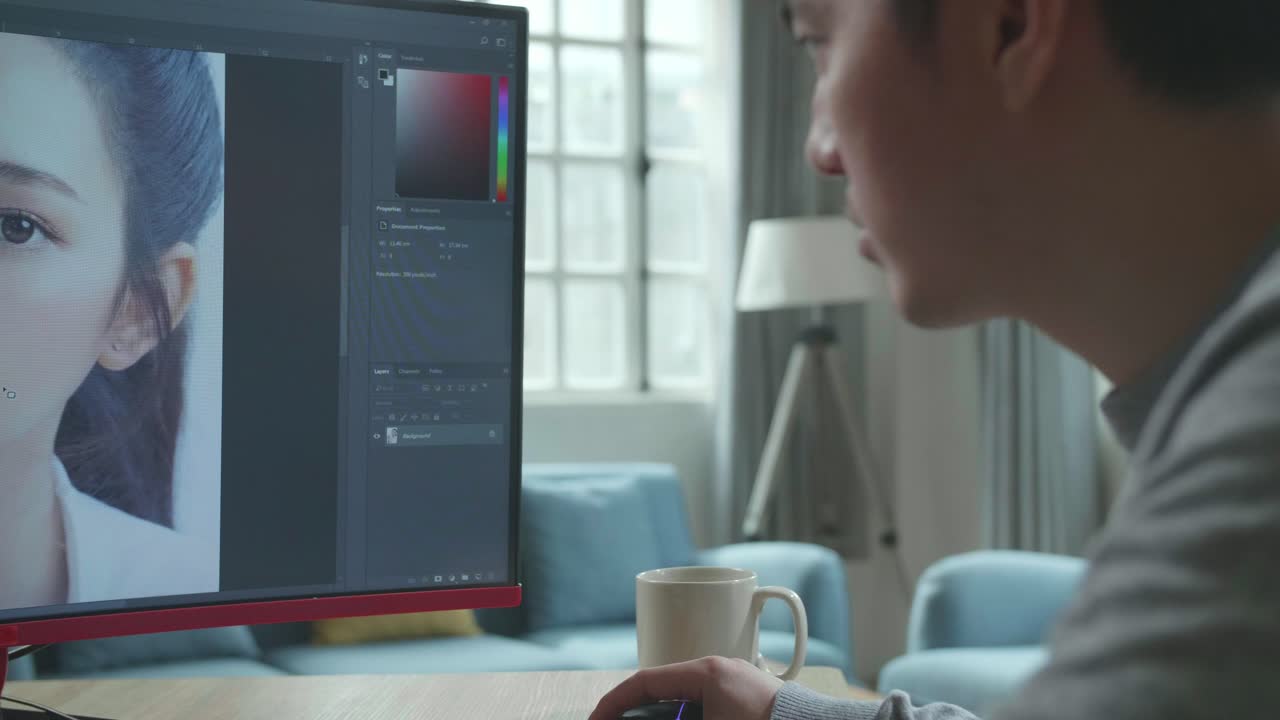Close Up Of Asian Cameraman In Long Sleeved T-Shirt Using Desktop Computer For Editing Photos While Working At Home.