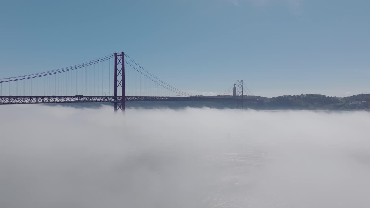Drone shot of Ponte 25 Abril in Lisbon, in the fog.