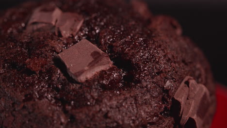 extremo primer plano macro de un muffin de barco de trozo de chocolate en un plato rojo