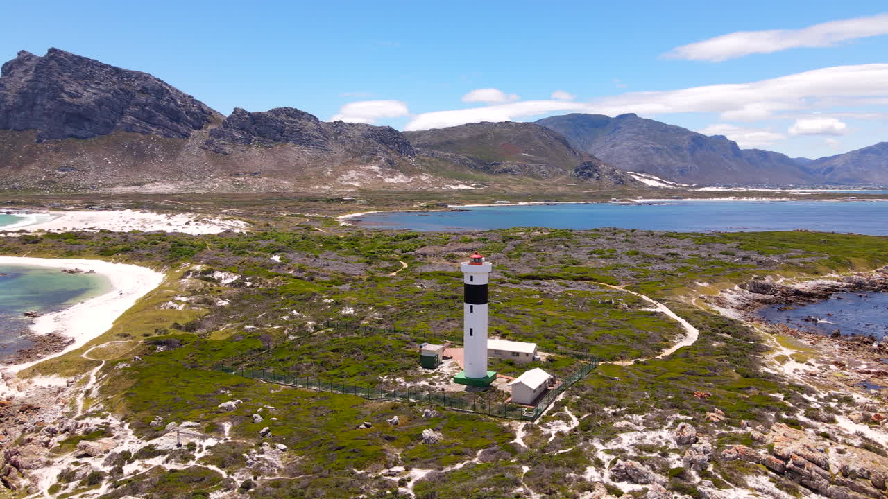 Praias cênicas e vegetação costeira ao redor do farol do Cabo Hangklip. Aérea.