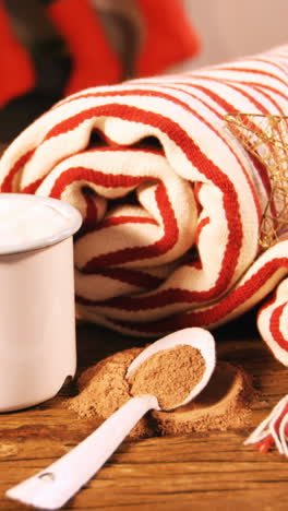 manta enrollada con cono de pino y taza de café