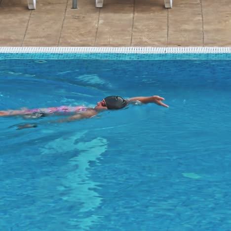 una joven sensual relajándose en la piscina.