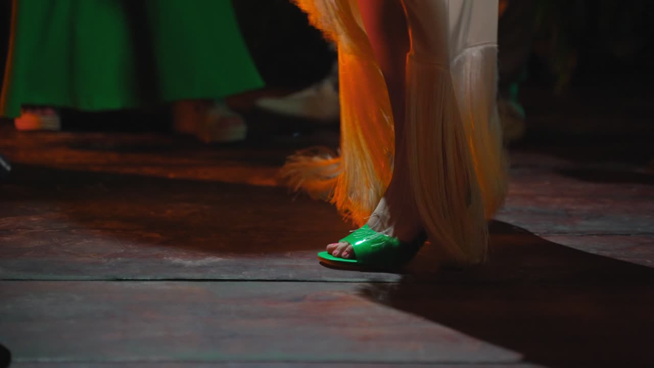 Close Up Of Woman's Feet Dancing In Long White Dress On A Club Venue Dance Floor With Colorful Strobe Lights Flashing During Night Time