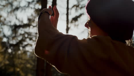 Female-tourist-gesturing-in-forest-on-sunny-day