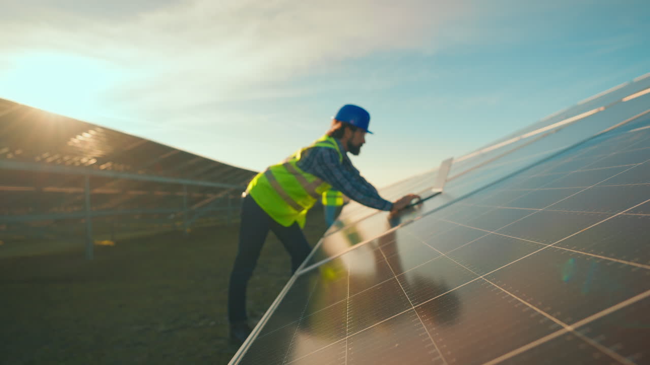 Engineer Inspecting Solar Panels at a Solar Farm