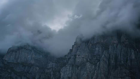 Nubes-De-Tormenta-Se-Acumulan-A-Lo-Largo-Del-Paso-De-Klausen-Mientras-La-Luz-Del-Sol-Baila-Sobre-Los-Acantilados-De-Granito-De-Urnerboden,-Suiza