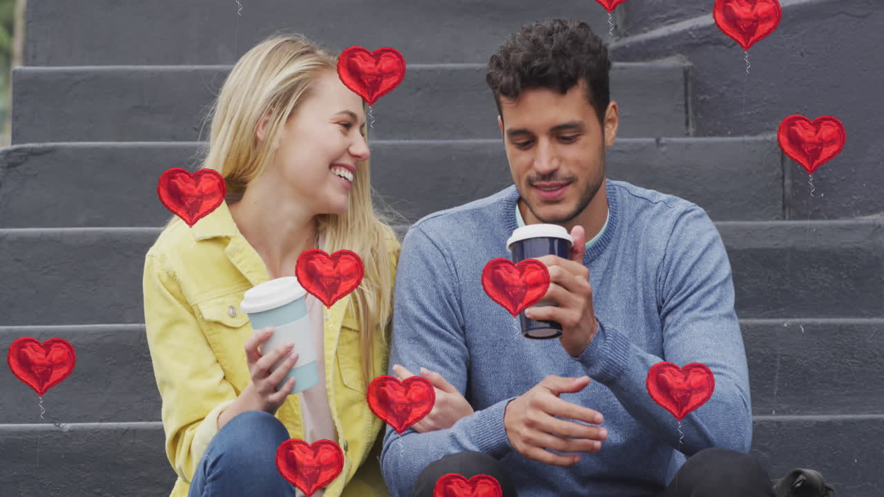 animación de iconos de corazón flotando sobre una feliz pareja caucásica hablando y bebiendo café para llevar