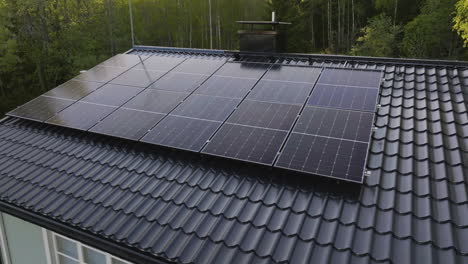 aerial view of solar power modules on a private house roof, summer evening
