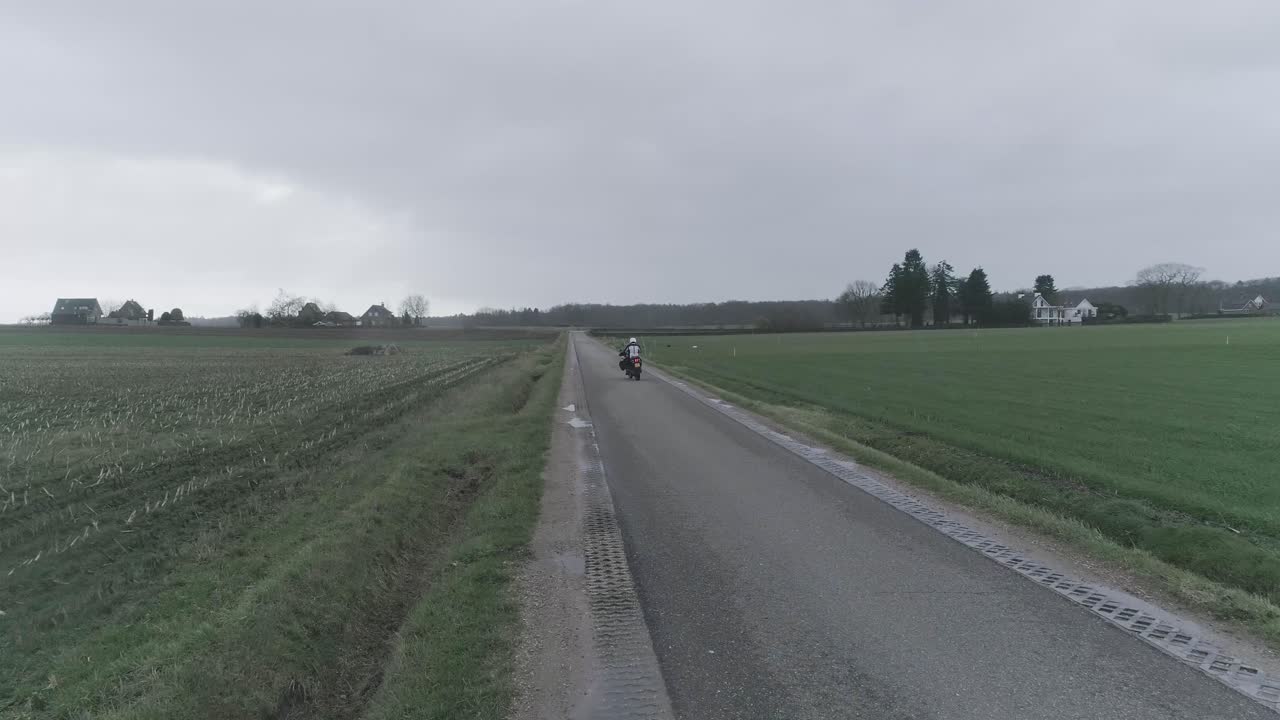 Drone shot of motorcycle driving away
