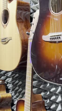 shop for acoustic guitars of various sizes and colors. concept of musical instruments. vertical video