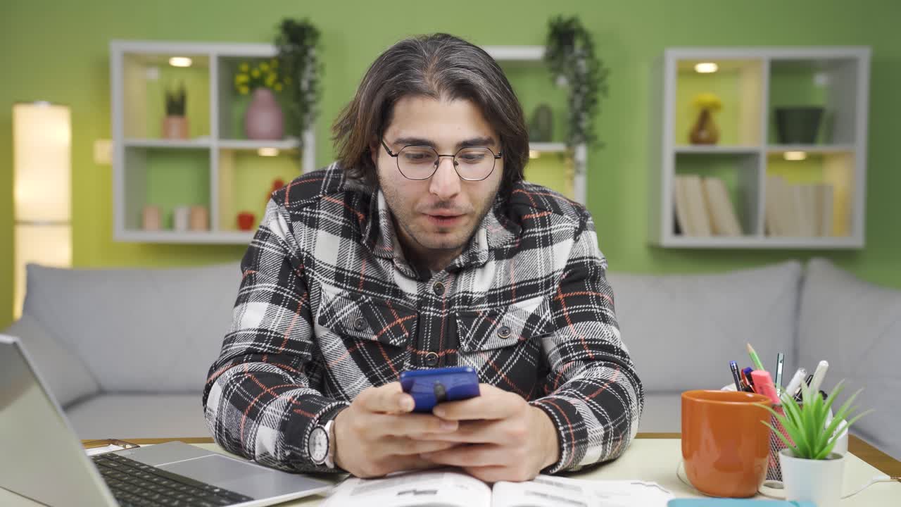 un joven asombrado usando un teléfono inteligente.