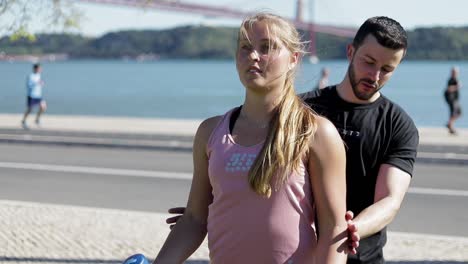 smiling blonde woman with ponytail doing exercises with dumbbells.