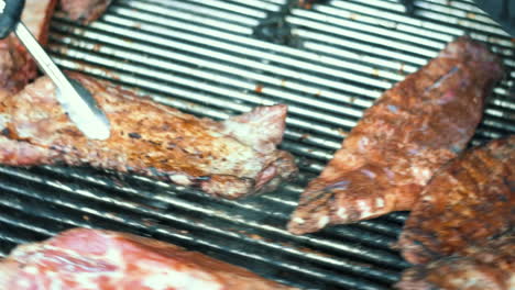 closeup male cooking with herbs pork outdoor. man grilling meat for picnic