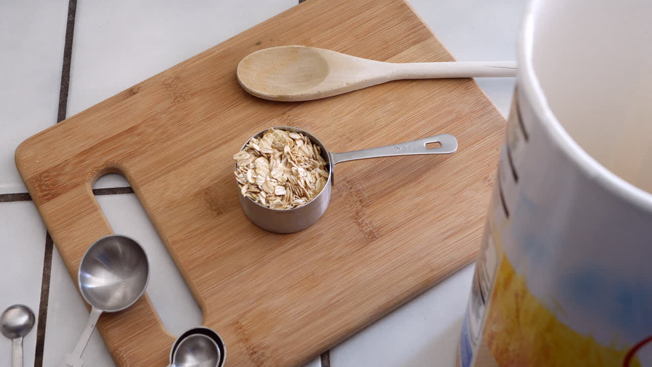 Oat whole grain cereal with kitchen utensils and a measuring cup for a healthy and nutritious oatmeal breakfast TOP DOWN
