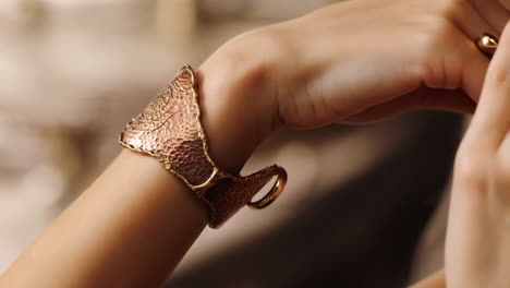 close-up of a hand wearing an ornate metal cuff bracelet