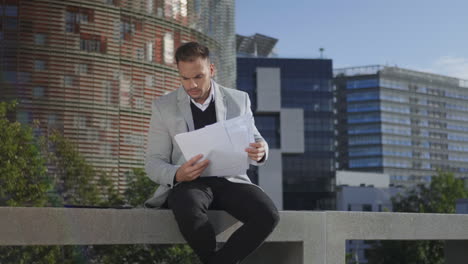 businessman looking graphs on documents at street. entrepreneur going for work