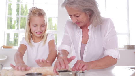 grandmother and granddaughter using a rolling pin