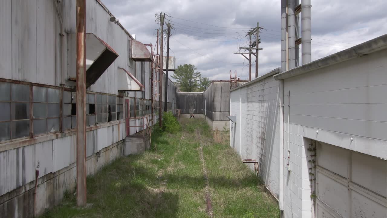 드론 영상 은 버려진 공장 에서 어져 있는 철도 트랙 을 가로질러 나아가고 있다