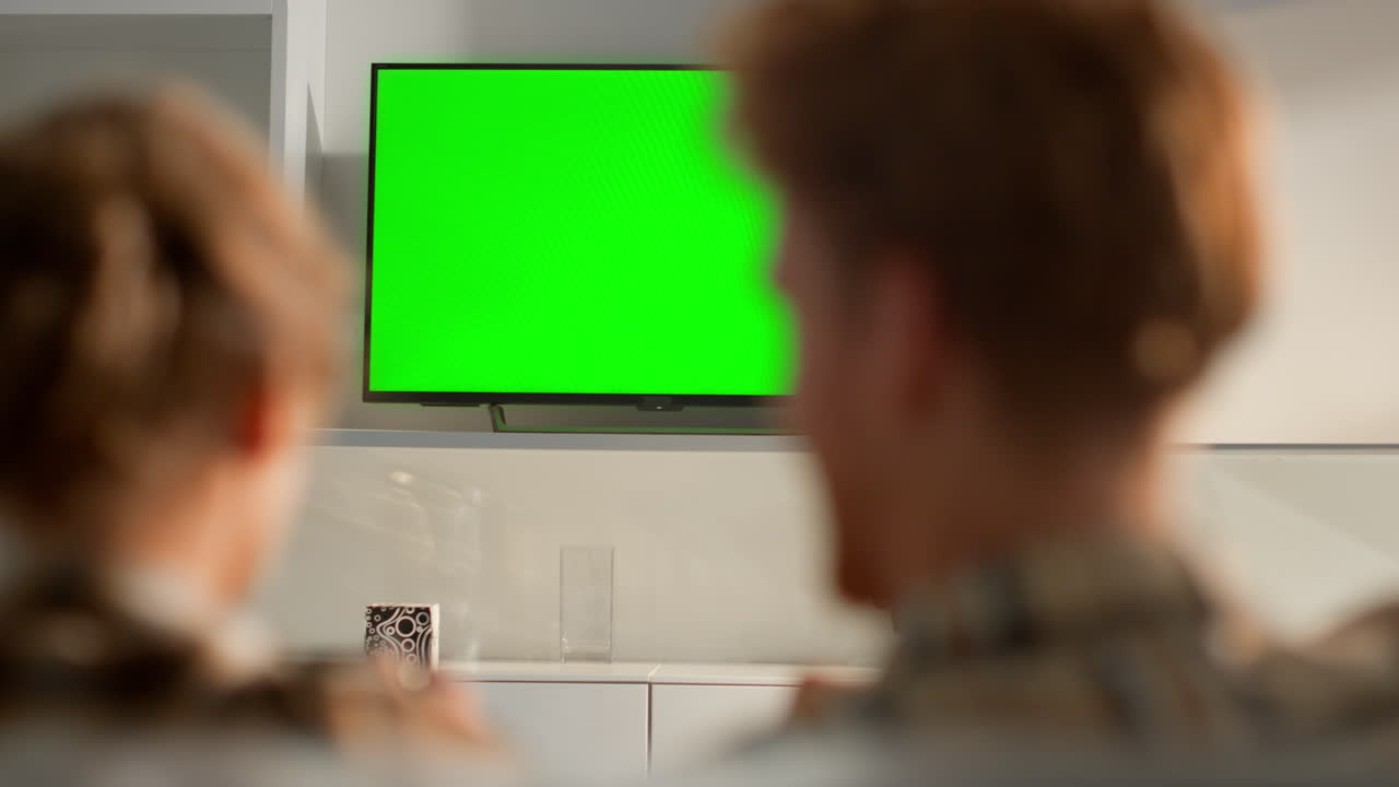 Couple playing games chroma key screen at home. Family leisure time with gamepad