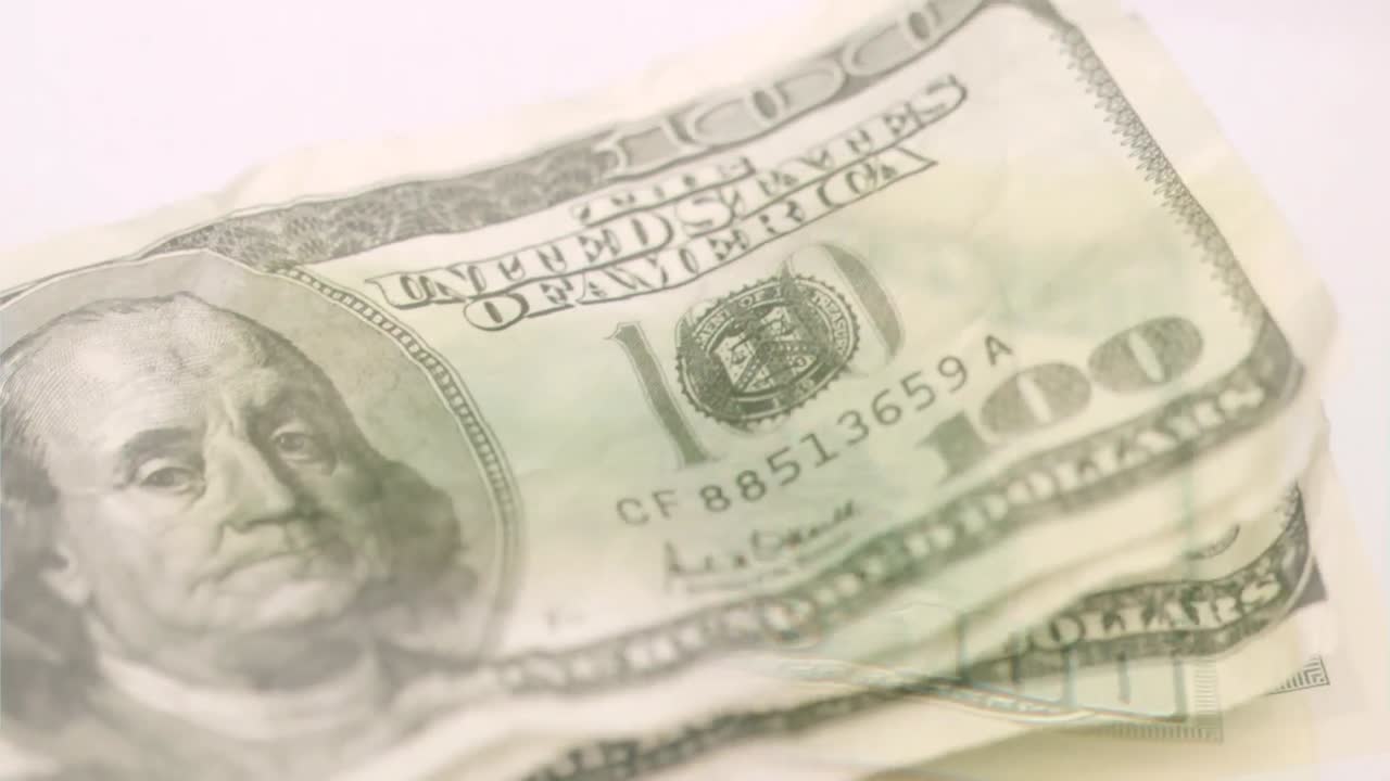 Animation af amerikanske dollar pengesedler, der falder ned over en hvid baggrund