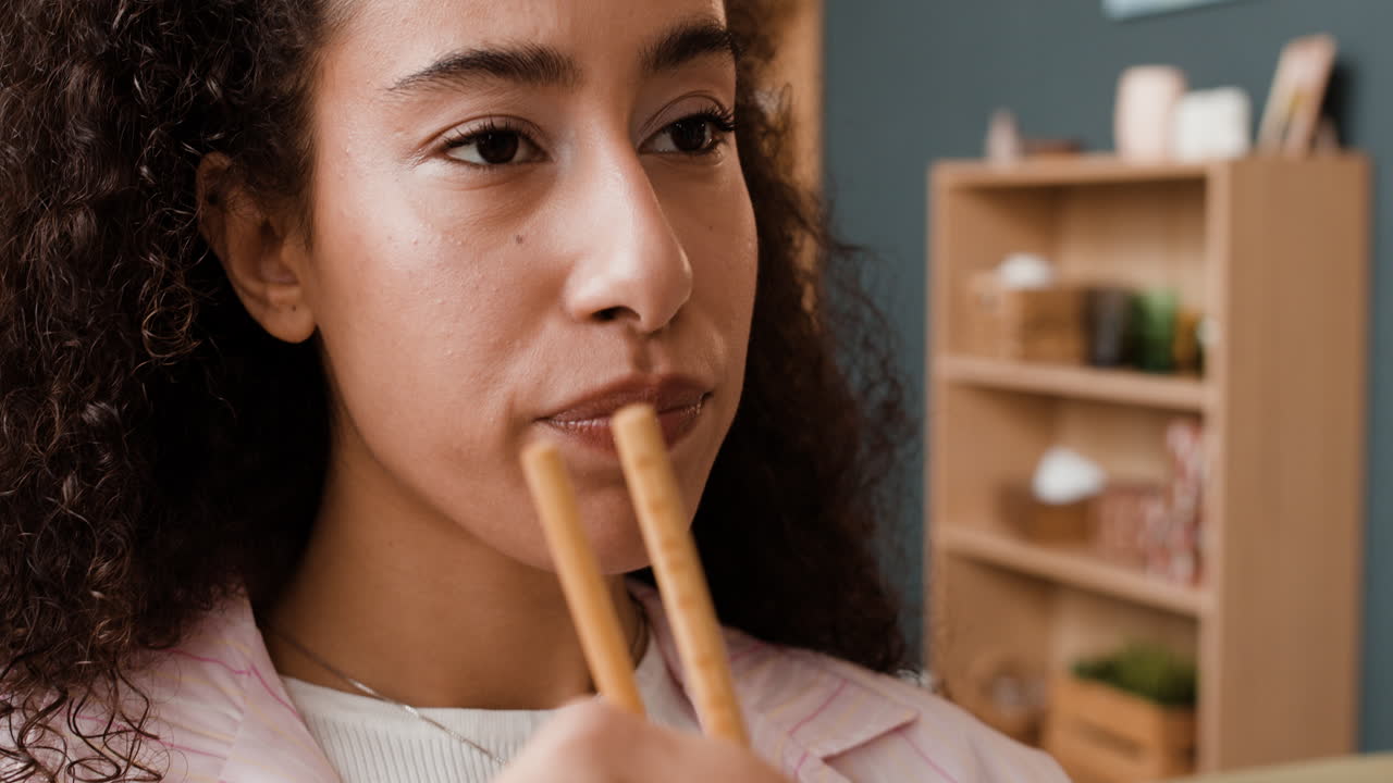 Close-up of a woman eating with chopsticks