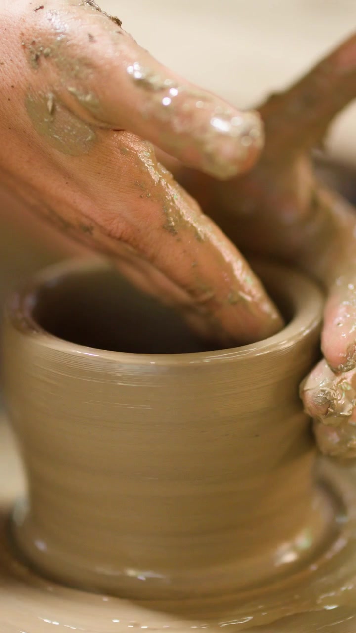 Primo piano delle mani di un vasaio che modellano un vaso di ceramica in uno studio a Nonthaburi, Thailandia