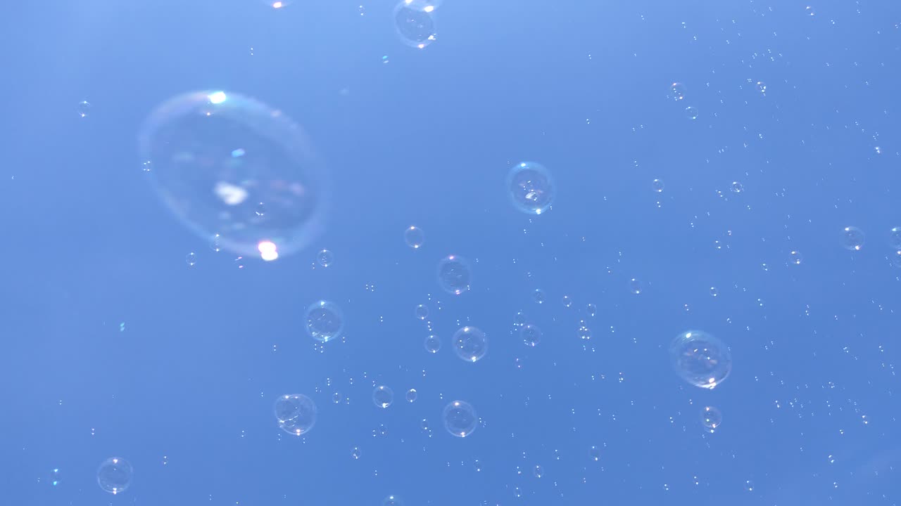 Summer sun and soap bubbles fly in the blue sky. Happiness, children's holiday, freedom.