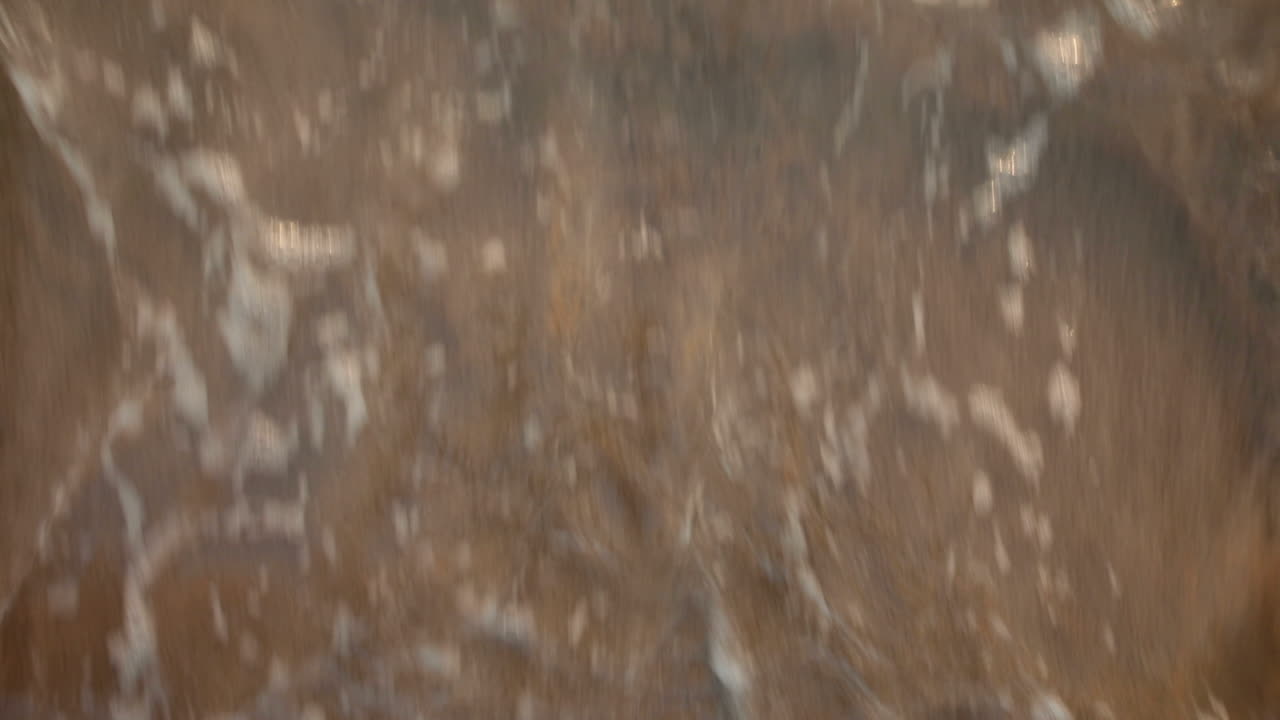 Number three written in the sand and washed by a wave