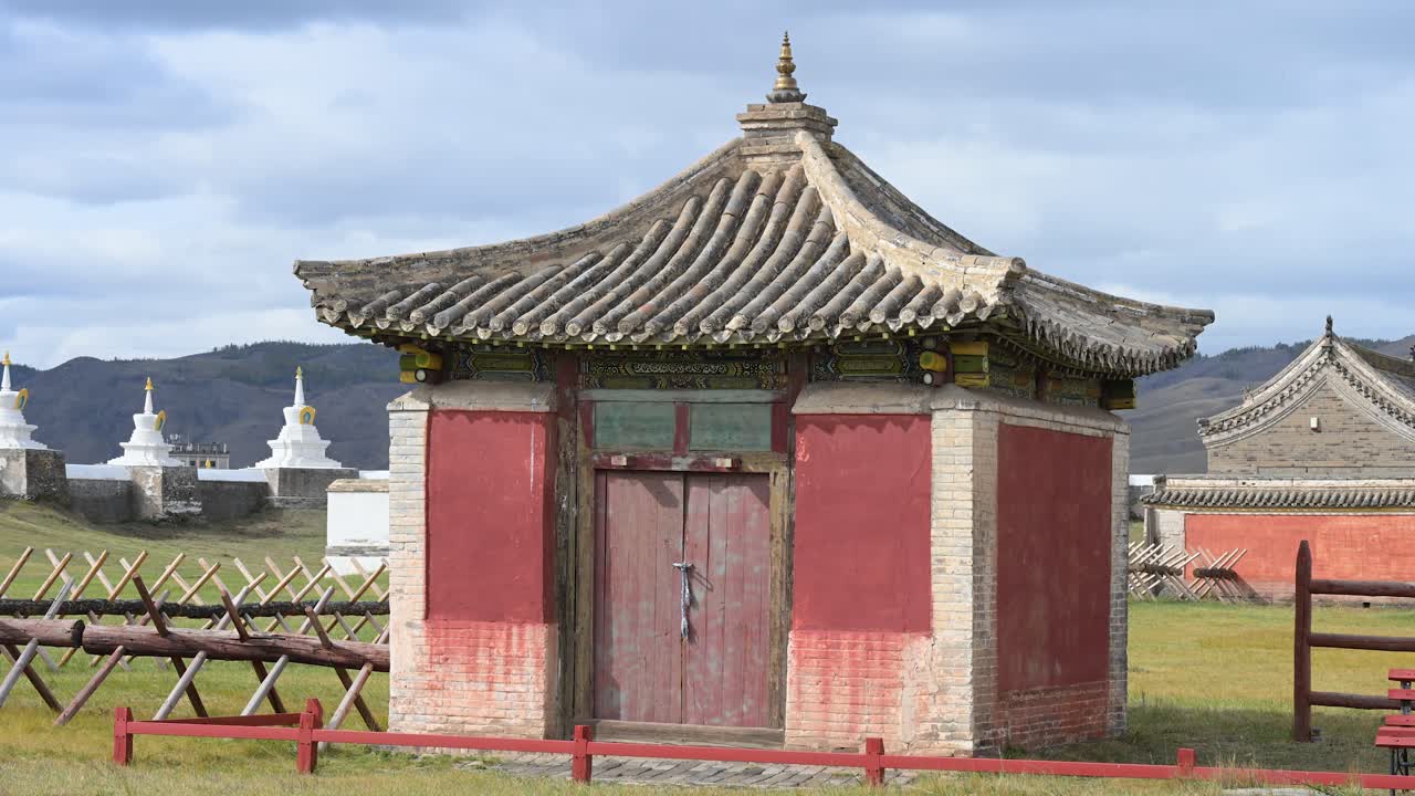 Detailed view of a temple pavilion at Erdene Zuu Monastery, Mongolia. The ancient structure features a traditional curved roof and red walls, showcasing Buddhist architectural heritage