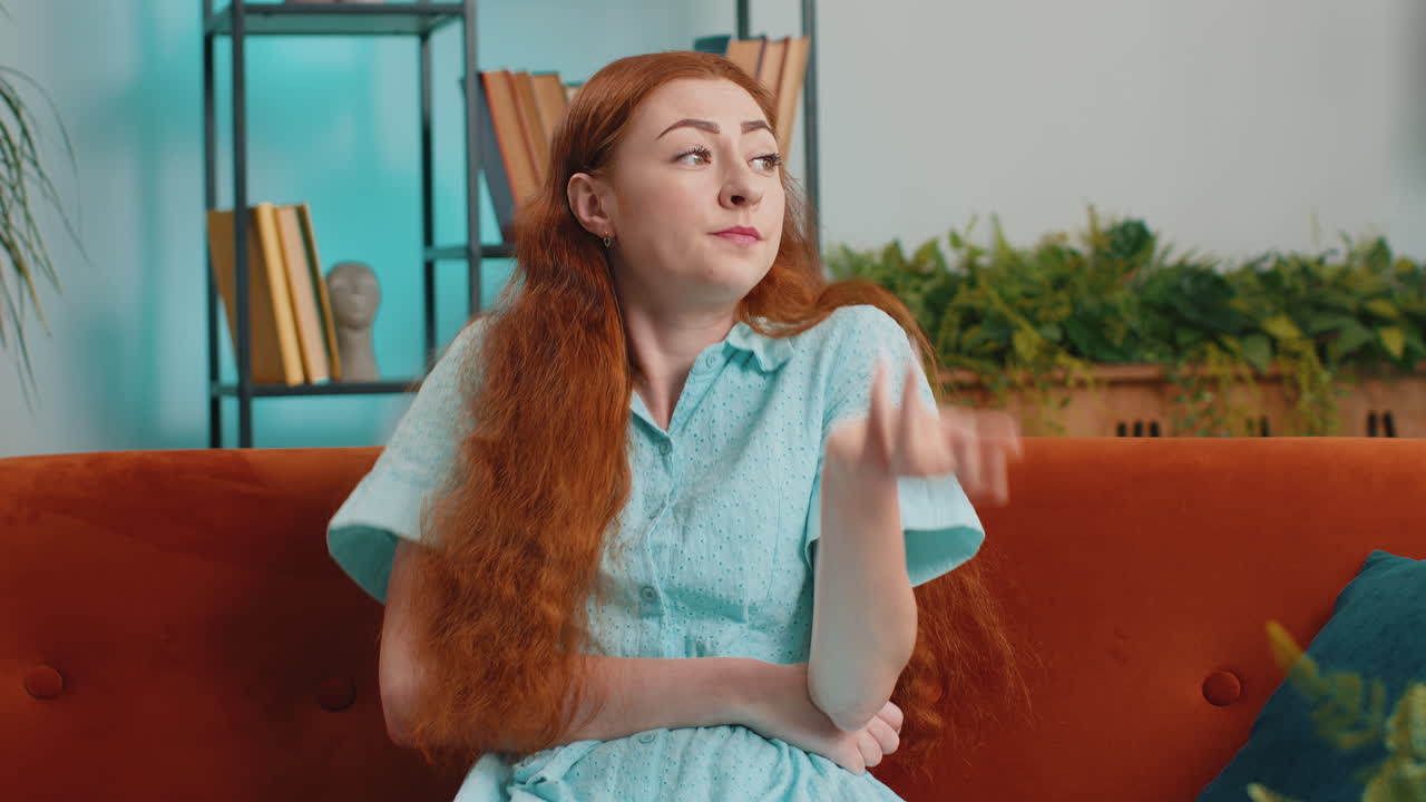 소파에 앉아 걱정하고 생각하고 있는 여자