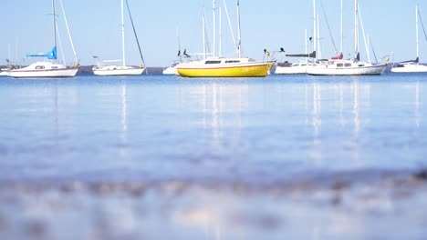 boats moored-up whilst tide flows over australian beach