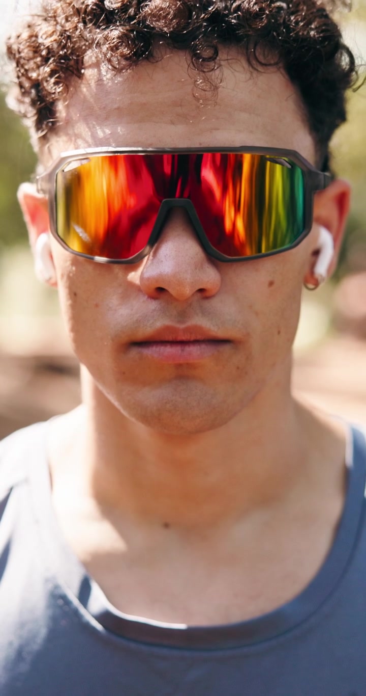 Sweaty Young Man Wearing Sports Sunglasses and Earbuds Outdoors