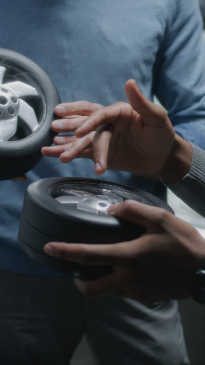 Hands examining prototype car wheels