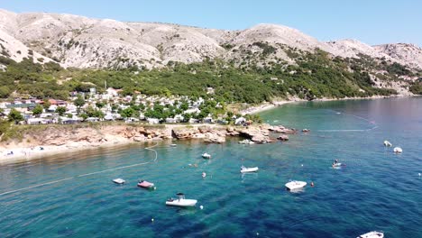 krk island, croatia - aerial drone view of the coast with boats, campsite and beaches at the adriatic sea