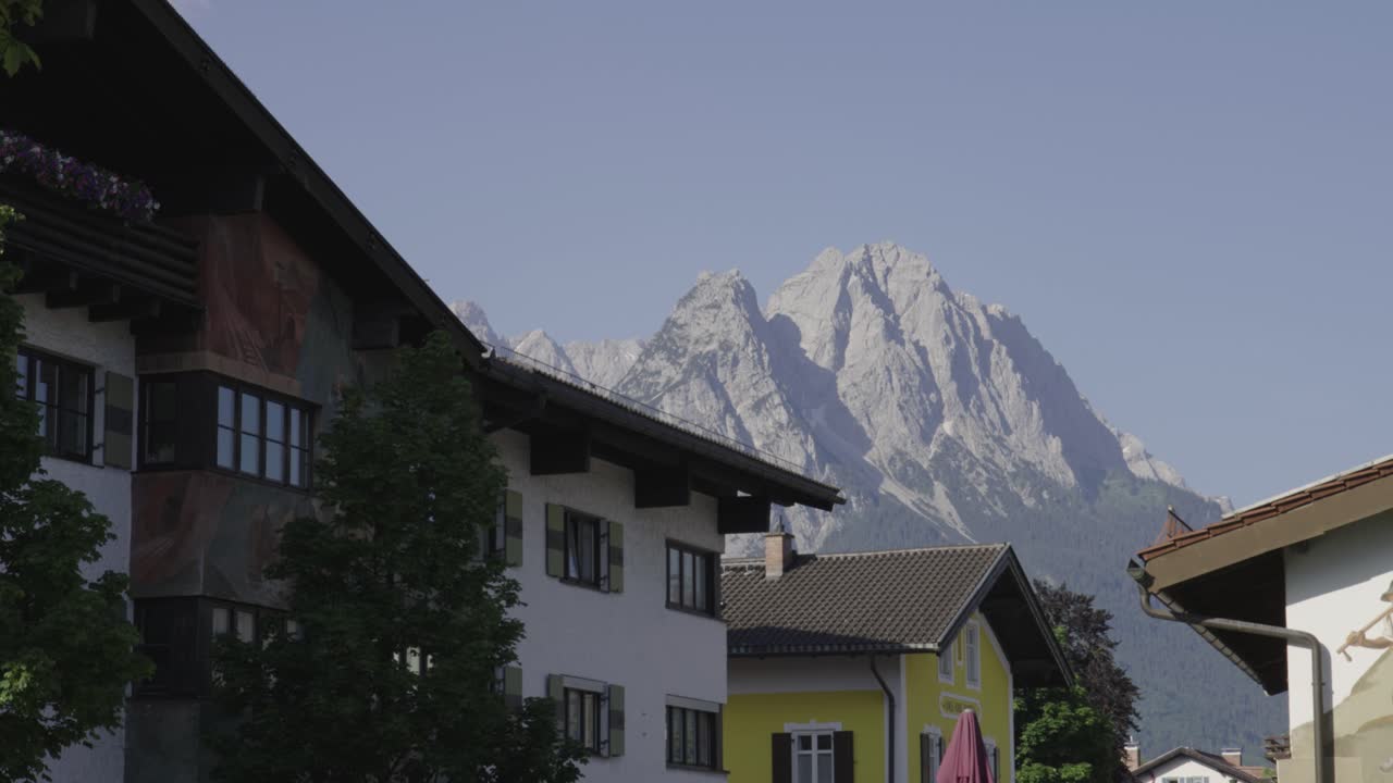 Alpine Farmhouse Styled Building With Mount Zugspitze In Background