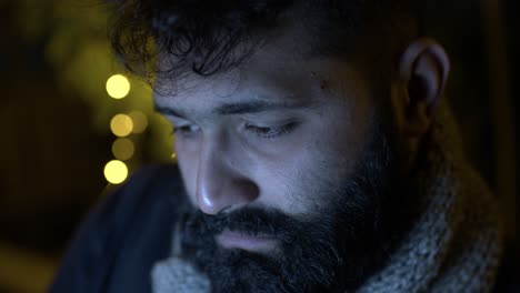 un estudiante con barba mirando profundamente la pantalla de una computadora portátil estudiando o escribiendo un libro